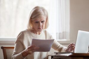 Pensionata dubbiosa mentre legge il cedolino della pensione